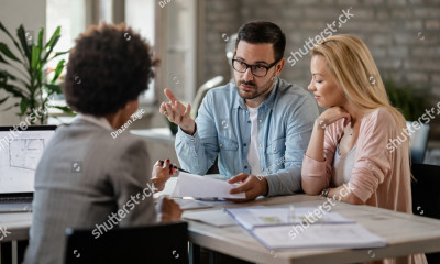stock photo mid adult couple discussing with financial advisor while analyzing documents on a meeting in the 1550078675